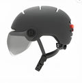 Adult cycling helmet with integrated red LED brake light on the back, shown in size M and L.