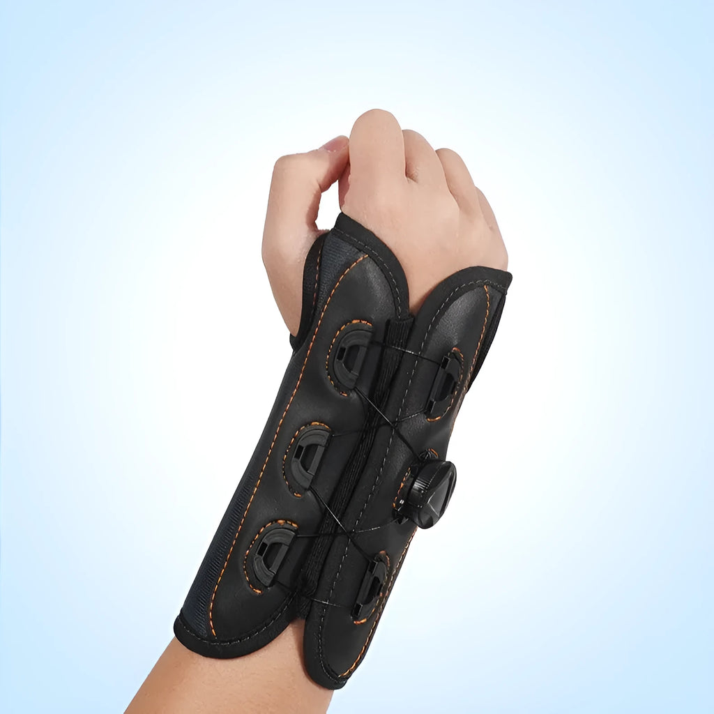 Black adjustable athletic wristguard with rotating pressure system on a flat surface