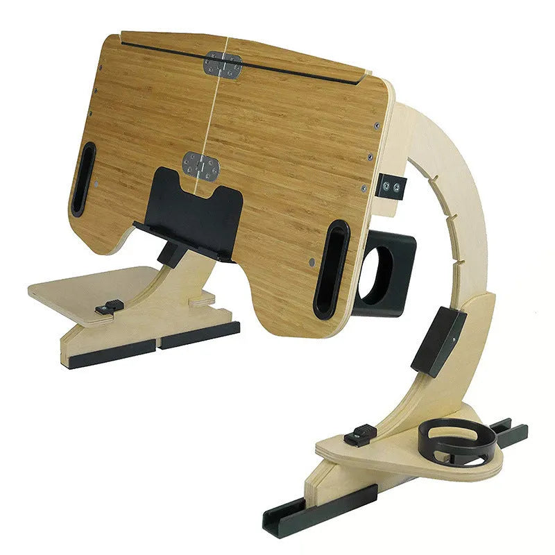 Wooden folding computer table with adjustable angle, shown in black finish on a bed.