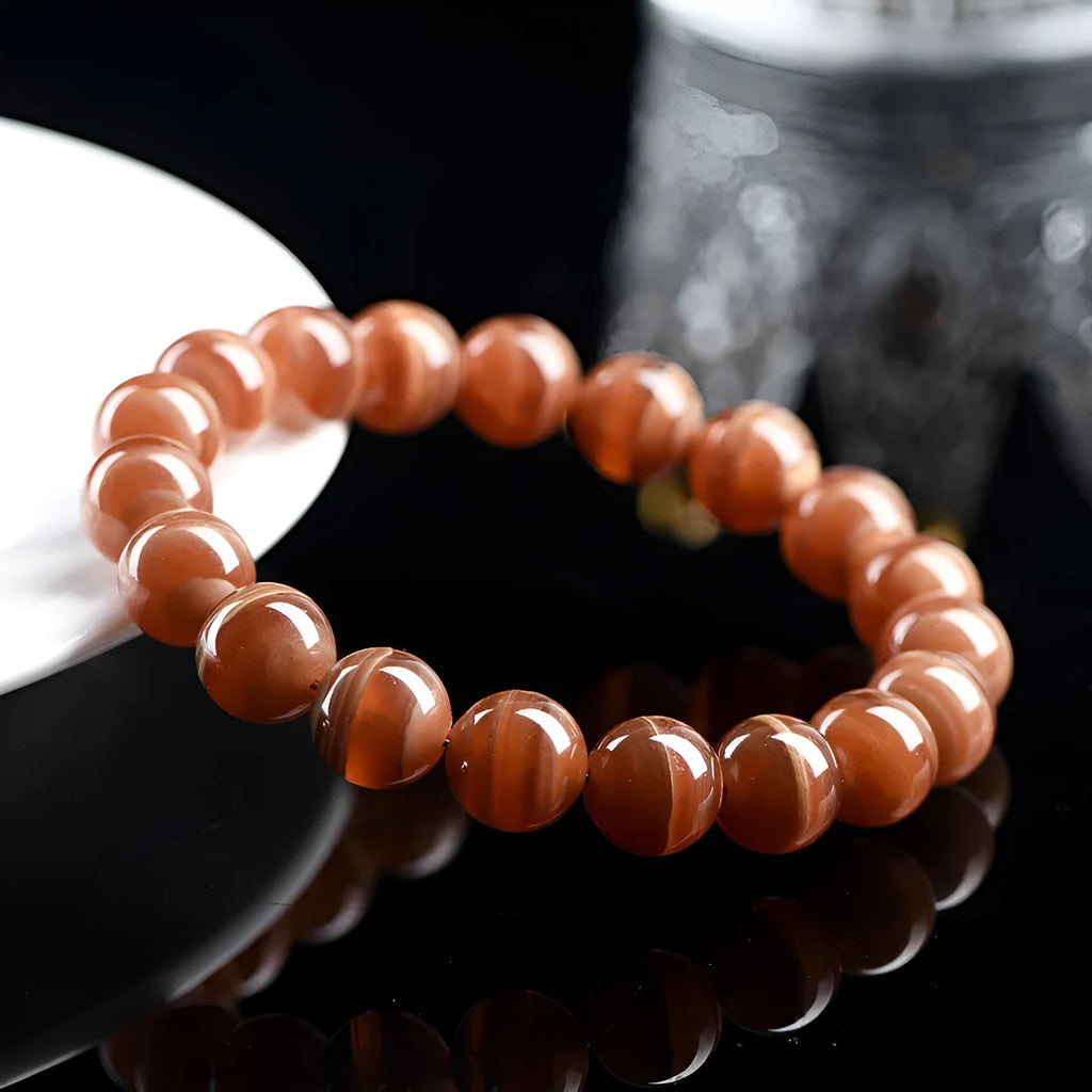Natural Old Mine Rhodochrosite round bead bracelet with Ruyi charm, shown in 6mm and 8mm size options.