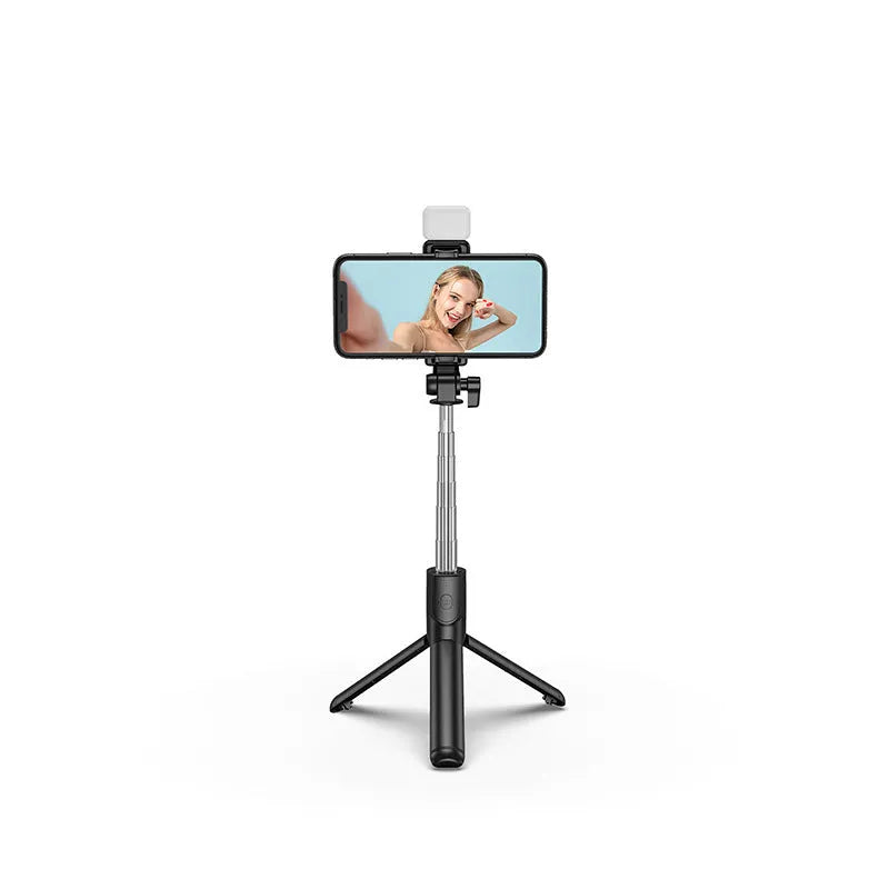 Black aluminium Bluetooth selfie stick with extended tripod legs and a phone mounted in the 360-degree rotating holder.