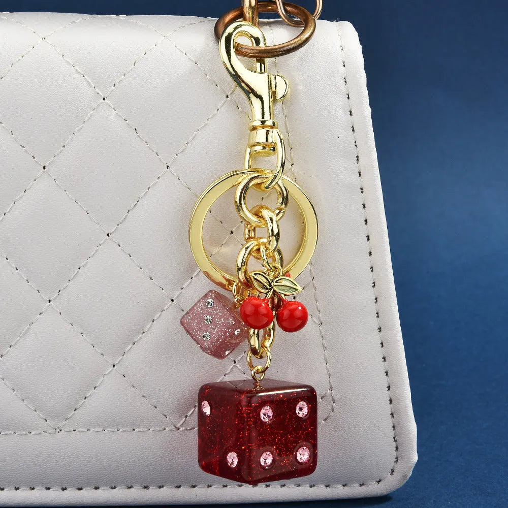 Vintage-style metal keychain with a square cherry red and white two-tone dice pendant on a metal ring.
