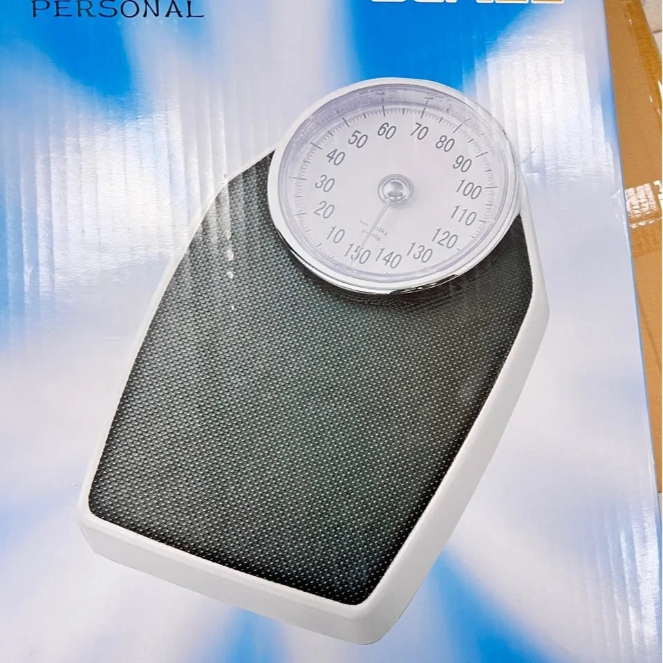 Black mechanical pointer bathroom scale on floor showing large dial and 47x35cm platform.
