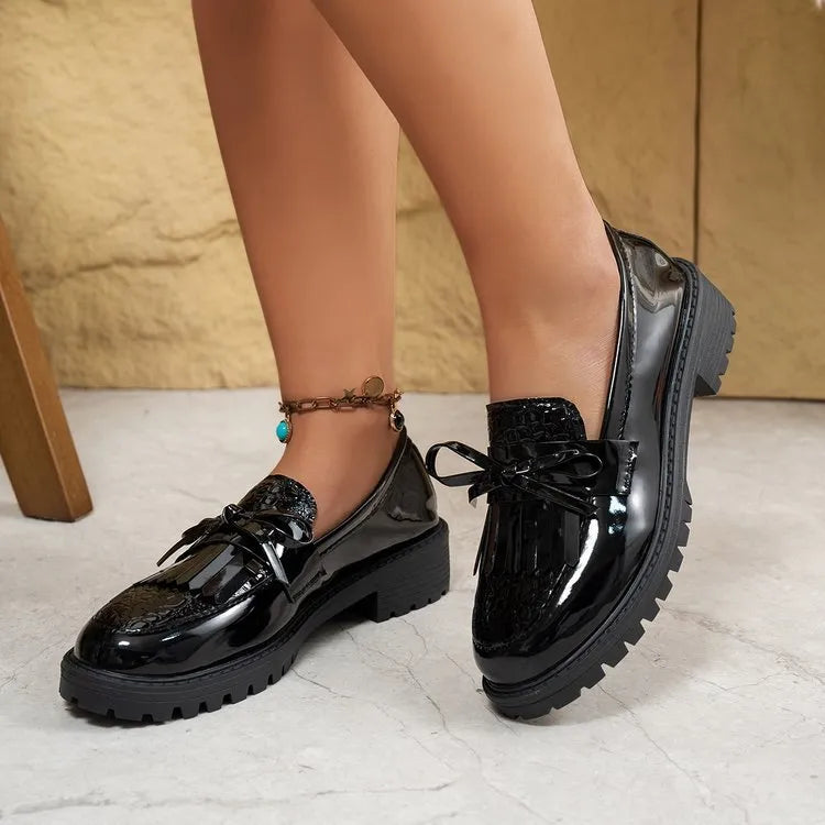 Brown women's flat loafers with a decorative bow on the front.