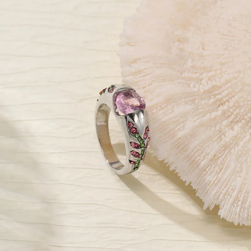 Leaf style zinc alloy ring with round zirconium inlay in gold colour on white background