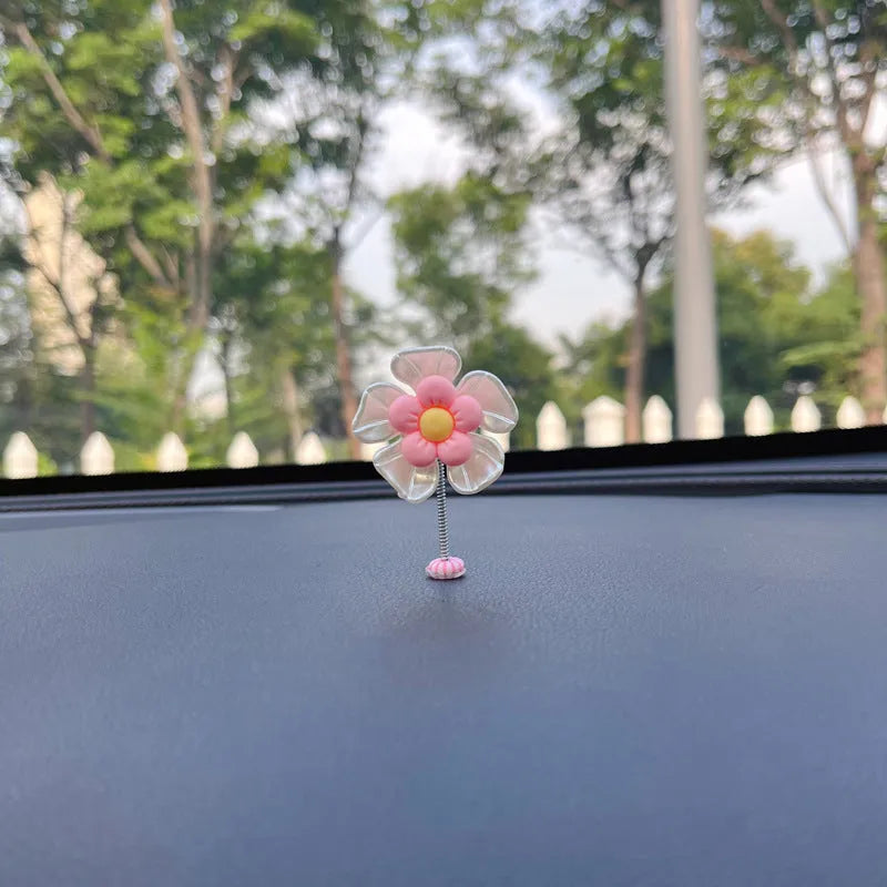 Small colourful plastic swing car decoration for dashboard or mirror.