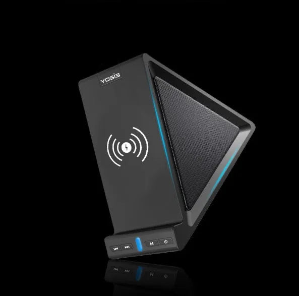 Black multifunctional Bluetooth speaker with integrated mobile phone stand and wireless charging pad on a desk