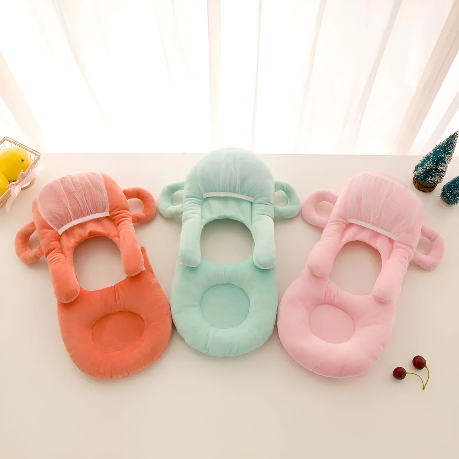 Pink plush baby feeding pillow on a carpet, showing its 30cm by 42cm size and soft texture.