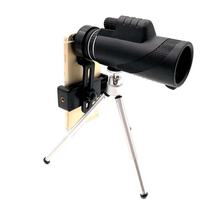 Black 40x60 monocular telescope with mobile phone attachment for photography on a table.