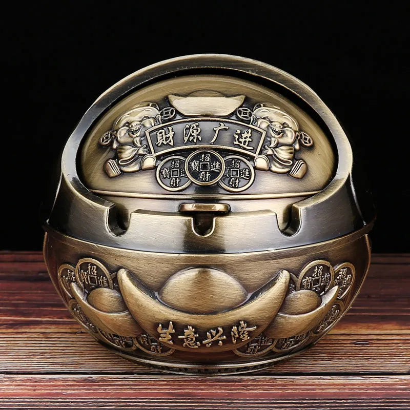 Alloy decorative ashtray in bronze with ornate peacock motif and cigarette extinguishing slot.