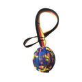 Yellow and camouflage coloured EVA floating dog ball with string in three different sizes on blue background