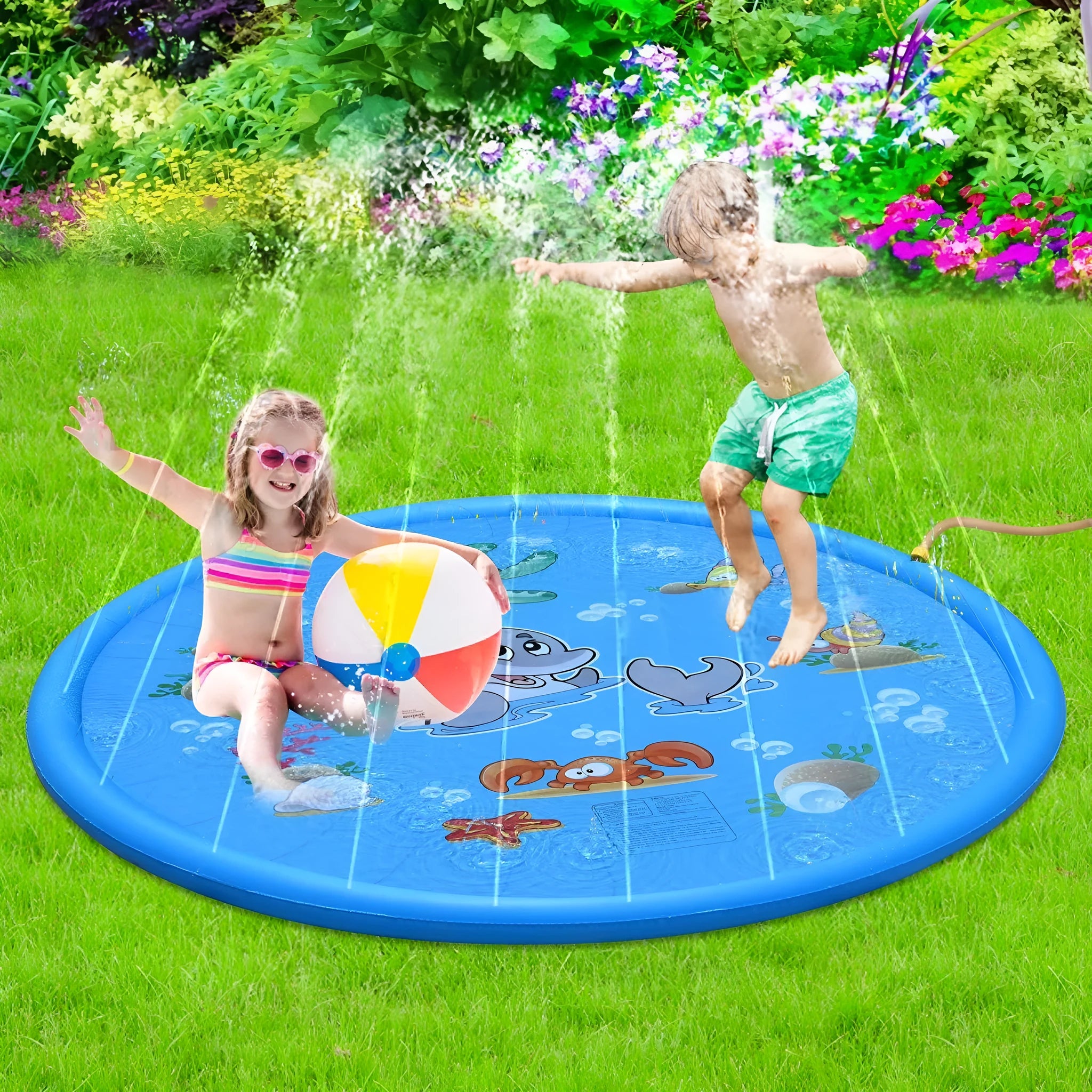 Blue children's water spray mat with marine animals laid on grass, connected to a garden hose.