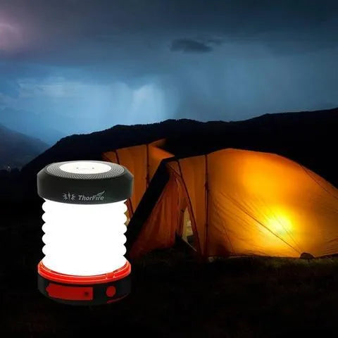 SolarBoom collapsible lantern in green with solar panel, collapsed for storage, on a wooden surface