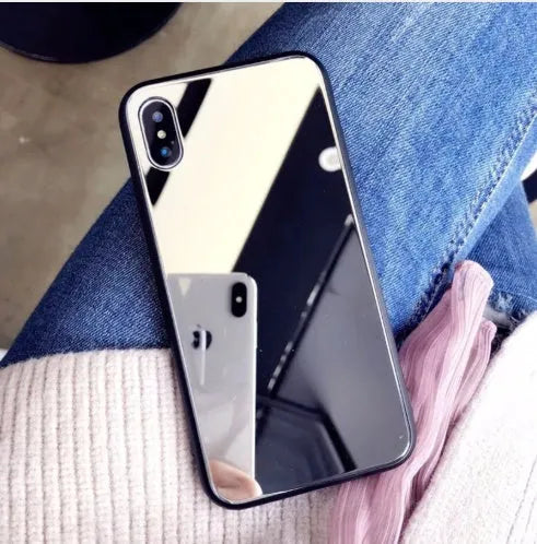Black mirror phone case for Apple iPhone models X, 7 Plus, and 8 Plus on a table.