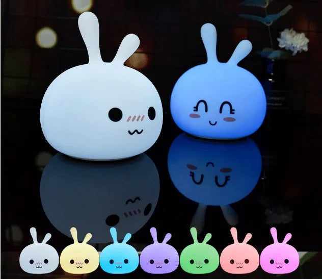 White marshmallow bunny LED night light with shy face or happy face option on a table.