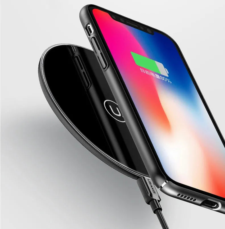 A black or white glass disc wireless charger on a table, showing its sleek design.