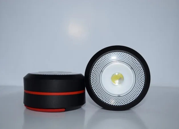 SolarBoom collapsible lantern in green with solar panel, collapsed for storage, on a wooden surface