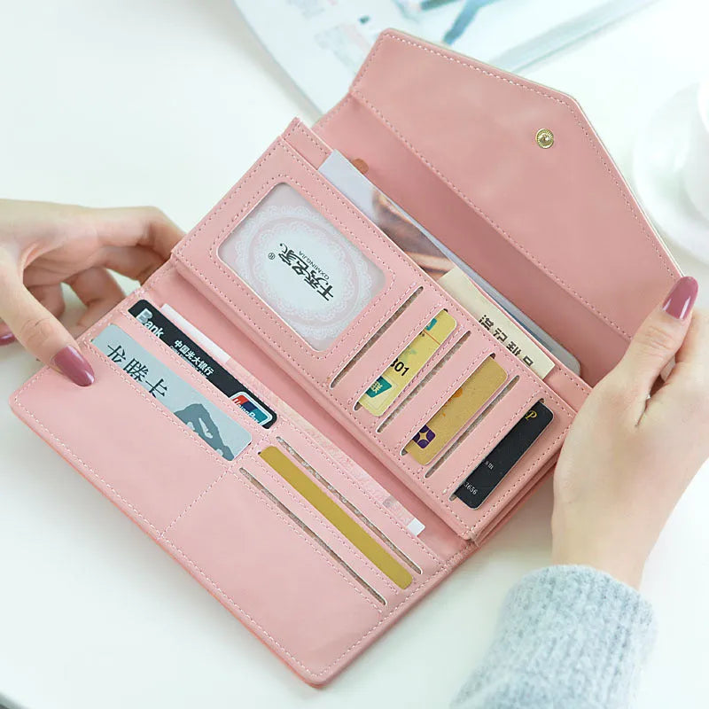 Women's black three-fold PU leather wallet with a metal clip, showing its open large capacity interior.