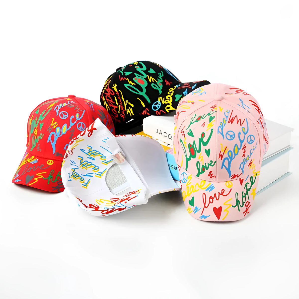 Children's cotton baseball cap with graffiti design, shown in black, pink, red and white colour options.