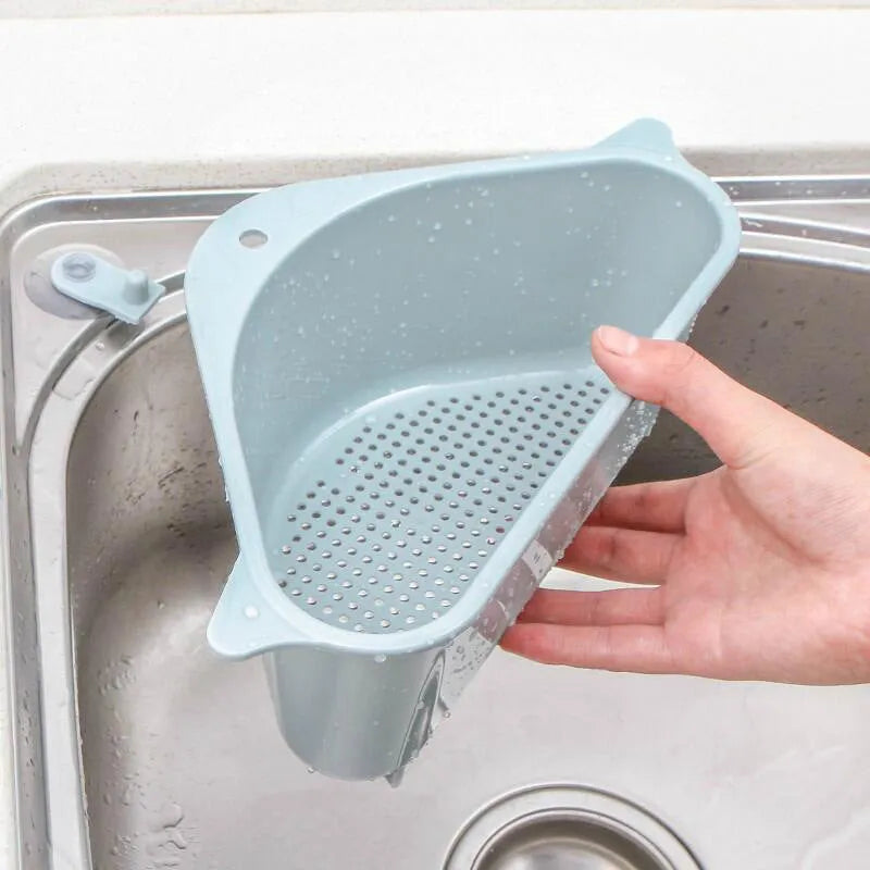 Beige plastic triangle kitchen sink rack holding a sponge and soap, hanging from a faucet.