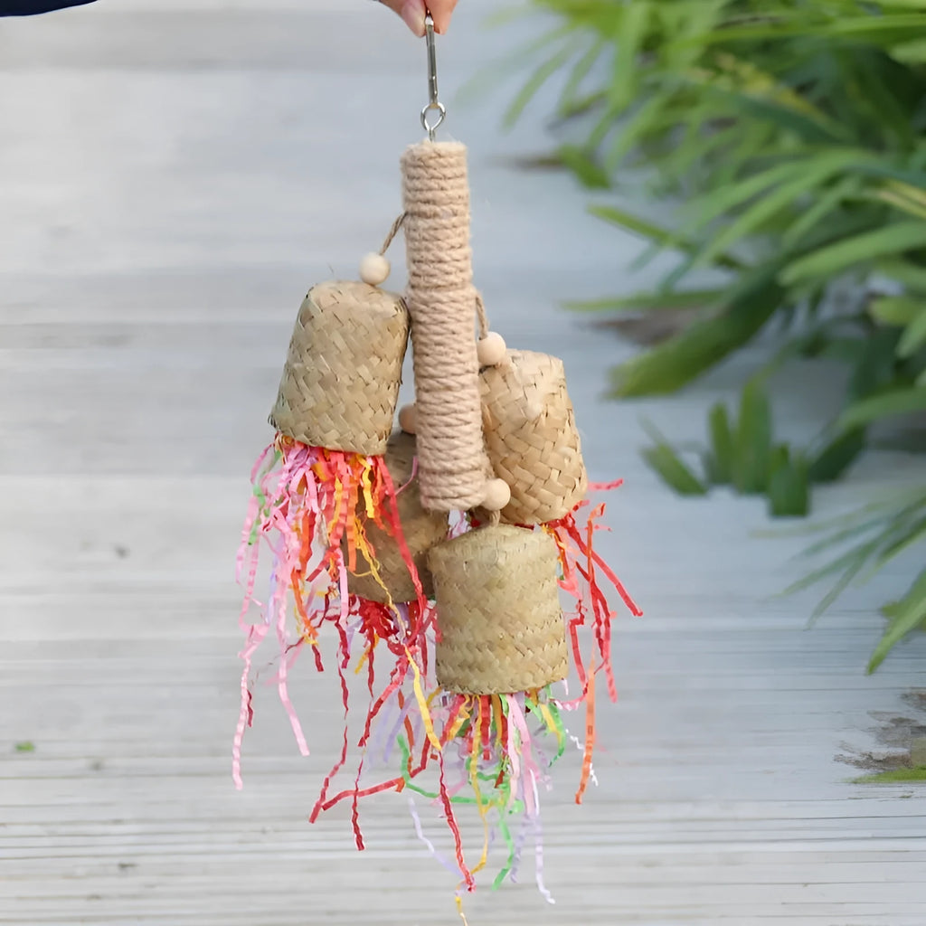 Wooden parrot chewing toy with colourful shredded paper decorations and sisal rope attachments
