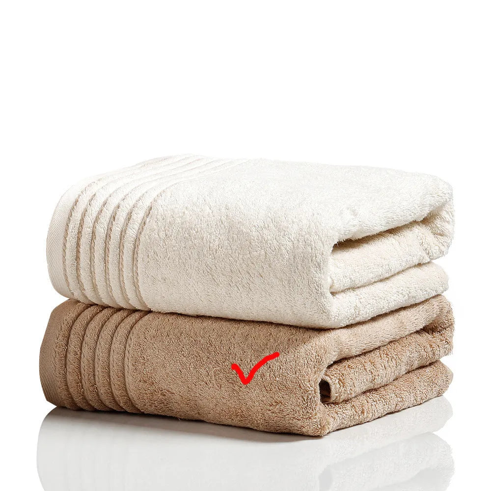 Set of three cotton towels in beige and brown colours, showing small, medium, and large sizes.