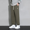 Men's loose grey cotton blend sports trousers with a drawstring waist on a hanger.