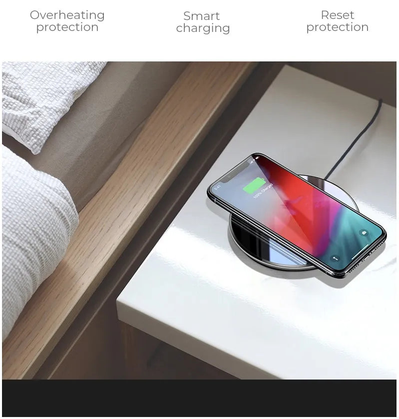 Black QI wireless charging pad on a desk, showing its non-slip silicone base.