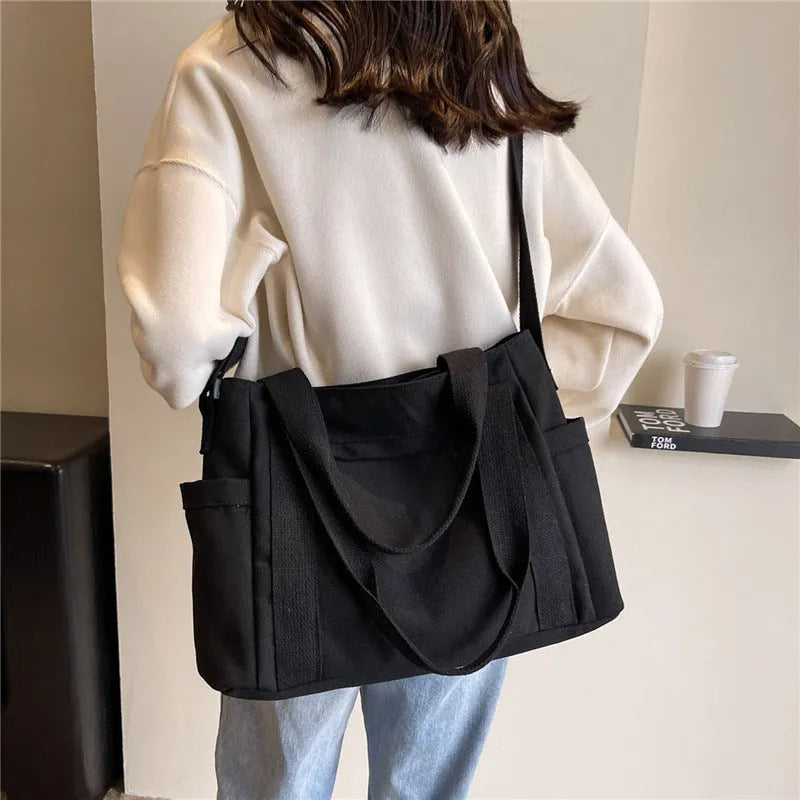 Large solid colour polyester canvas shoulder tote bag for women with outer pocket.