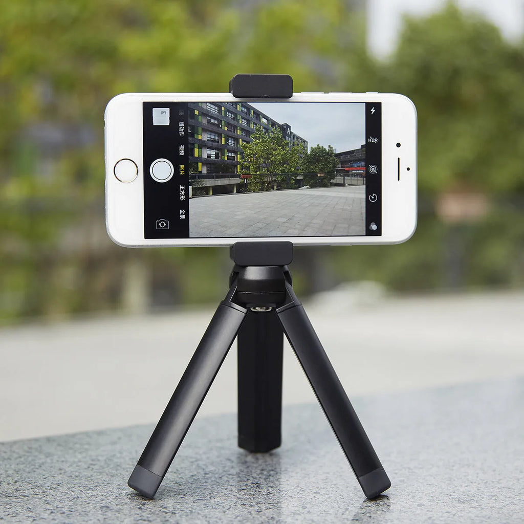 Aluminium alloy handheld bracket accessory for mounting an iPhone onto a table top tripod.