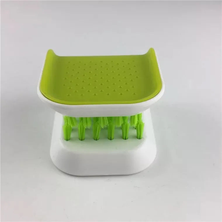 Blue U-shaped plastic brush for cleaning kitchen forks, knives and spoons on a countertop.