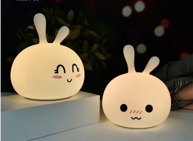 White marshmallow bunny LED night light with shy face or happy face option on a table.