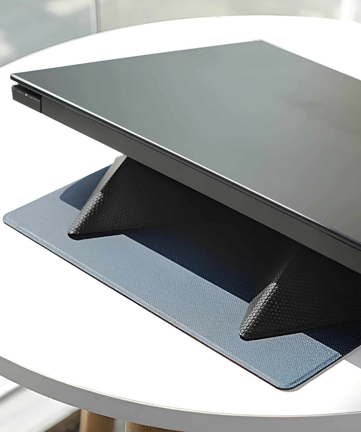 Blue foldable laptop cooling stand with anti-slip surface, shown open and closed, next to a laptop.