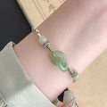 Women's green and copper ethnic-style bracelet with jade buckle weaving and a peace buckle charm.