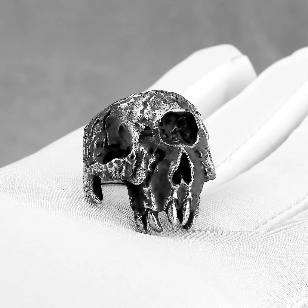 Close-up of a silver-toned alloy ring with a detailed one-eyed skull design on a finger.