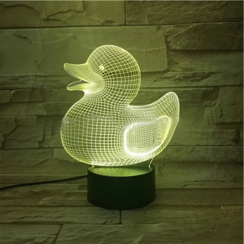 Little yellow duck 3D night light with remote control on a table, showing colourful LED illumination.