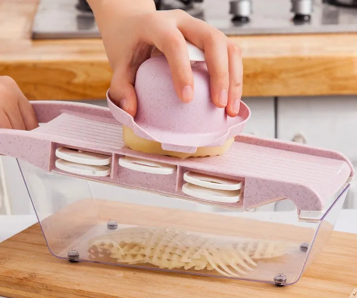 Multi-blade vegetable cutter with wheat straw body and seven stainless steel blades for slicing and dicing on a kitchen counter.