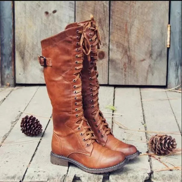Black chunky heel high leg boots with a round toe and low heel on a plain background.