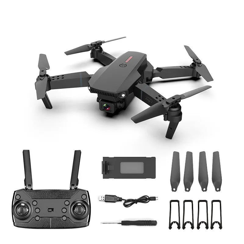 Grey foldable 4K dual camera drone with remote control, spare blades, and charging cable on a neutral background.