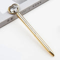 Golden metal pen with crystal love ball and diamond decoration on a white background