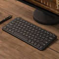 White ultra-thin wireless keyboard and mouse set with USB nano receiver on a wooden desk.