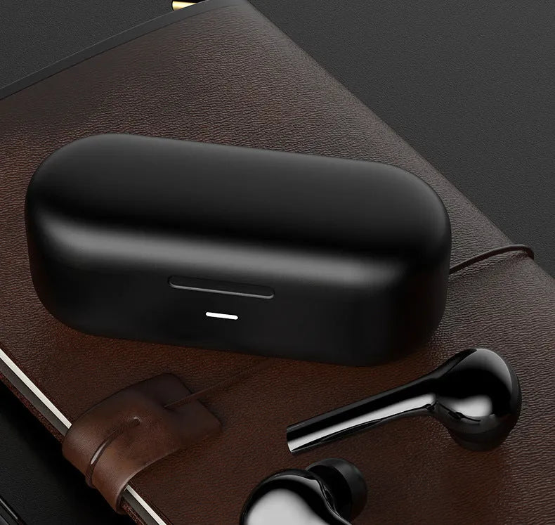 Black and white wireless touch control earbuds with a charging case on a table.