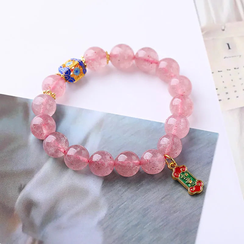 Pink strawberry quartz crystal bracelet with hand-woven construction and traditional Ruyi symbols