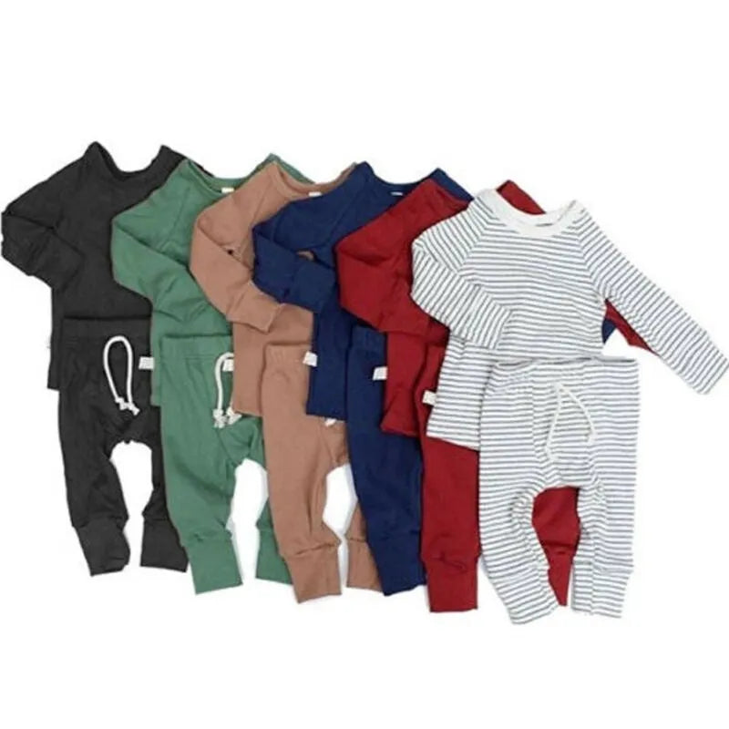 A baby wearing a blue cotton romper tracksuit set with a cartoon pattern, showing the one-piece design.