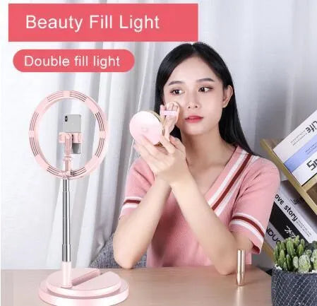 Portable 290mm LED selfie ring light in black on table, showing centre phone holder and adjustable brightness button