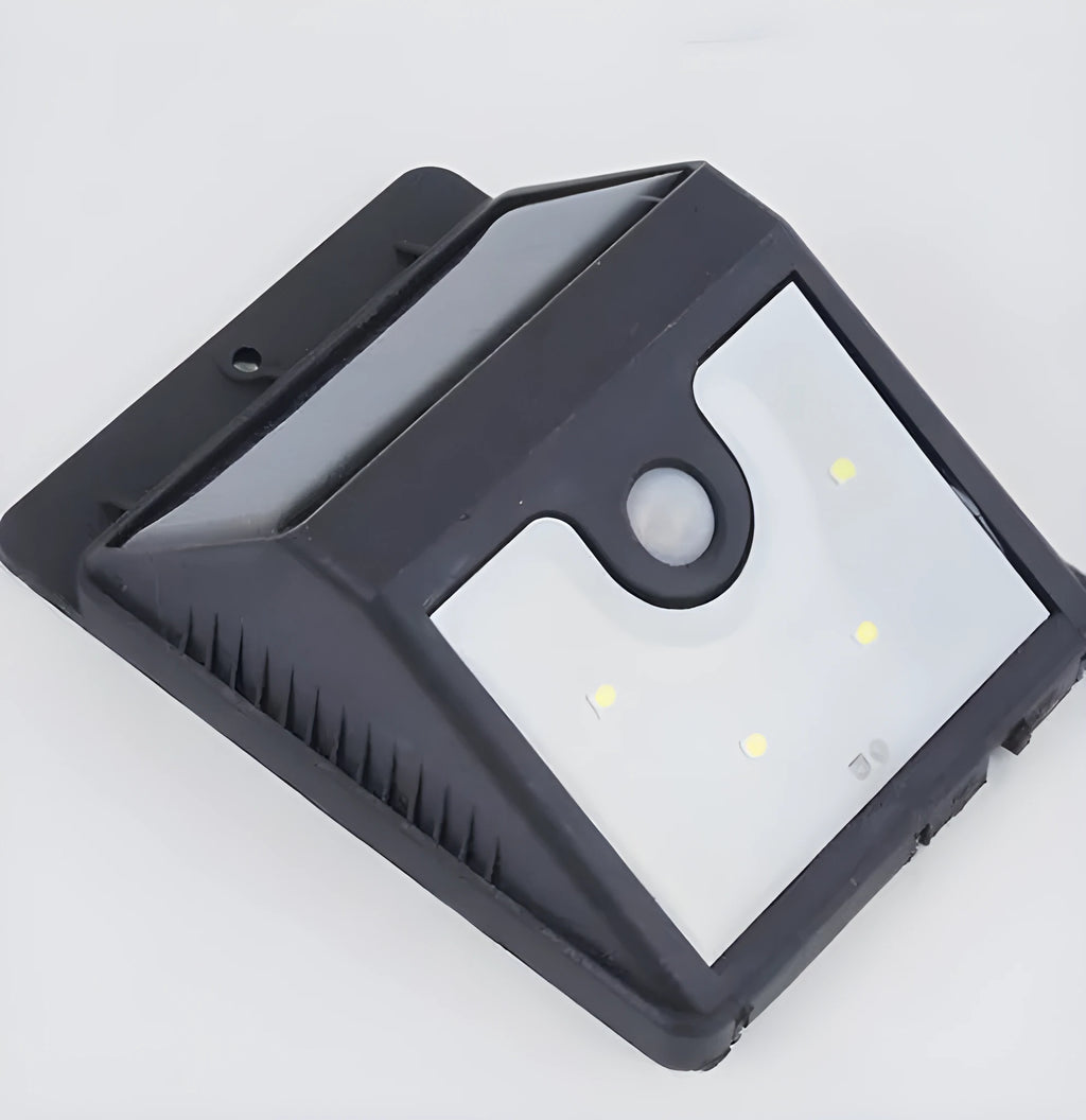 Set of four white square solar-powered LED security lights with motion sensor mounted on a brick wall