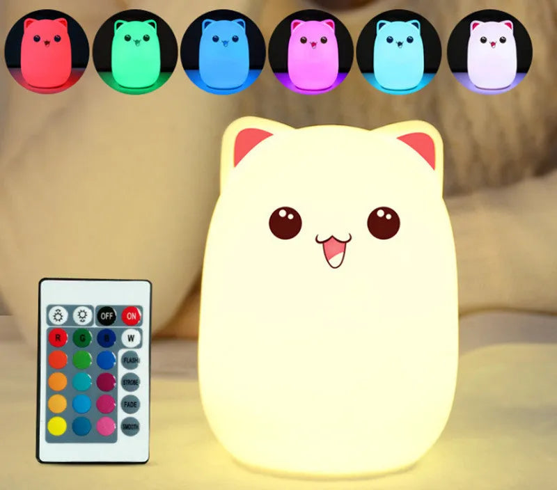 Cartoon silicone clapping night lamp in pink with USB charging cable on a bedside table