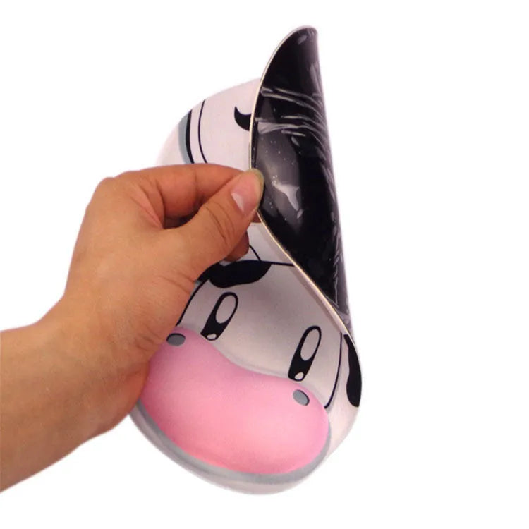 Super soft silicone cow pattern wrist rest mouse pad on a desk, showing non-slip base and ergonomic hand support.
