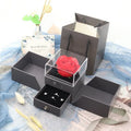 Blue jewellery gift box open to show a plastic eternal rose inside, with space for accessories.