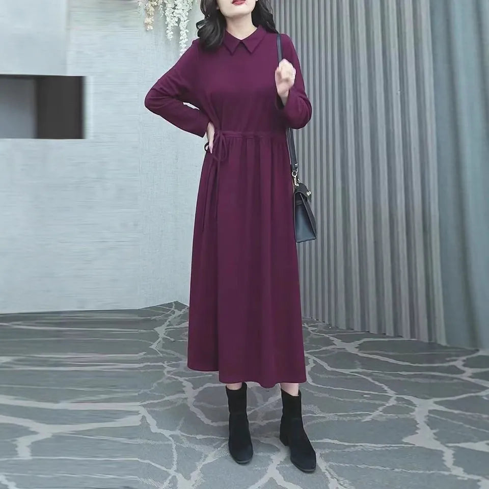 Purplish red women's long-sleeve maxi dress with extra-long cuffs and urban commute style on a hanger.